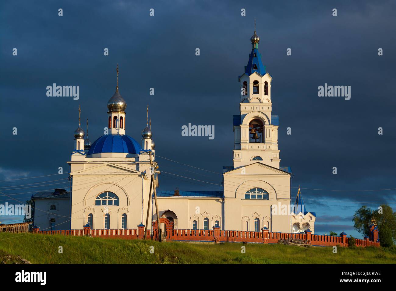 an old Orthodox church on the river bank.sunset sun and black clouds ...