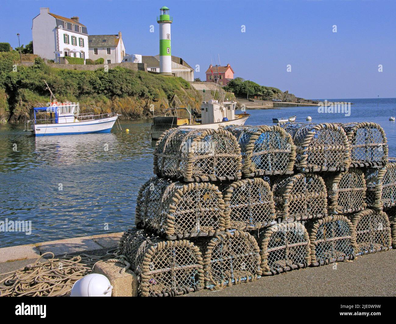 France, Finistère Clohars-Carnoët, Doëlan, entrance to the fishing port with the lighthouse and crayfish pots Stock Photo