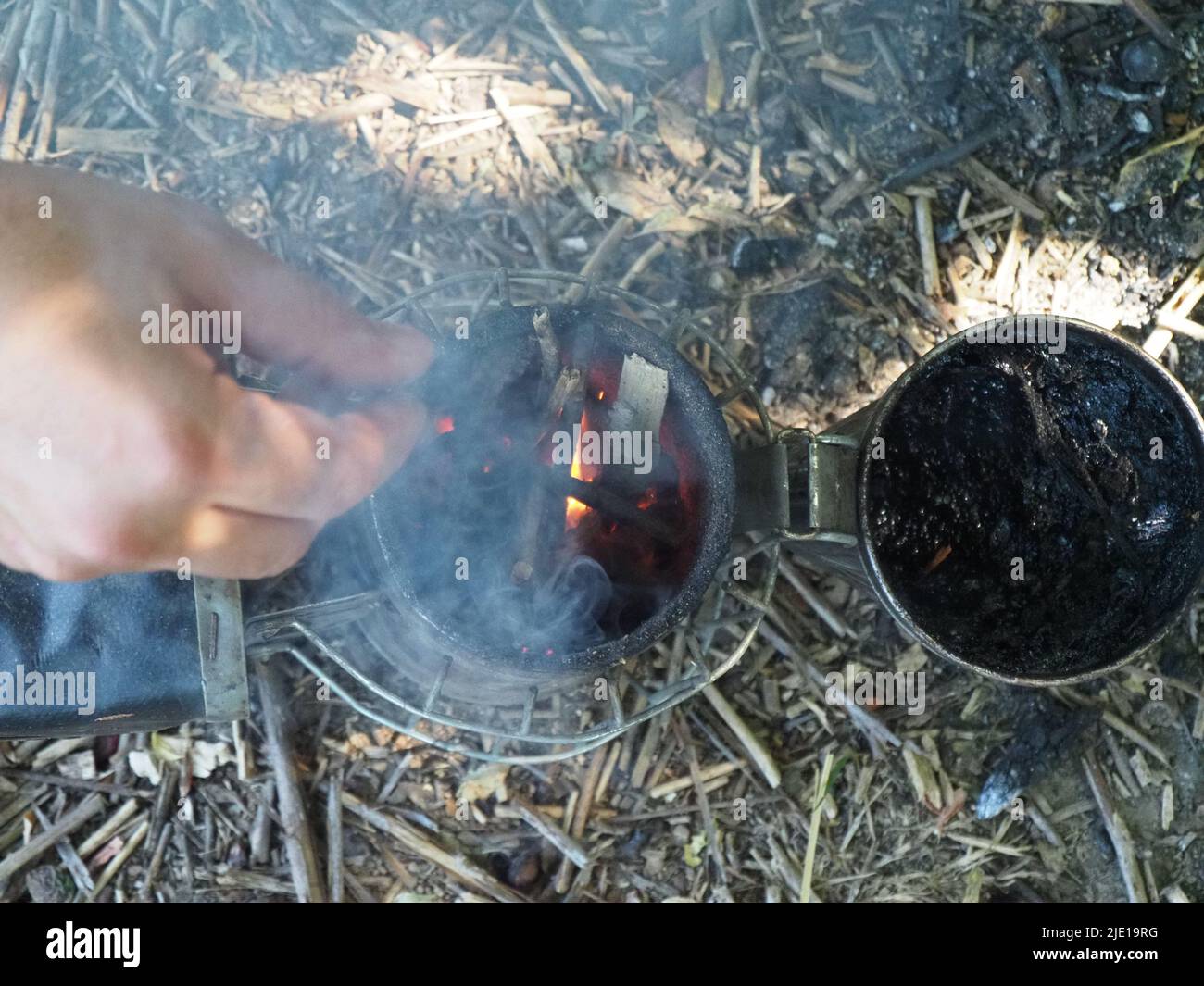 starting a bee smoker before harvesting honey hives in the farm Stock
