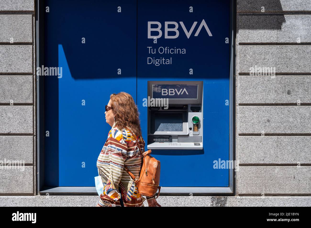 Madrid, Spain. 24th June, 2022. A pedestrian walks past an ATM machine at the Spanish multinational Banco Bilbao Vizcaya Argentaria SA (BBVA) bank branch in Spain. (Photo by Xavi Lopez/Sopa Images/Sipa USA) Credit: Sipa USA/Alamy Live News Stock Photo