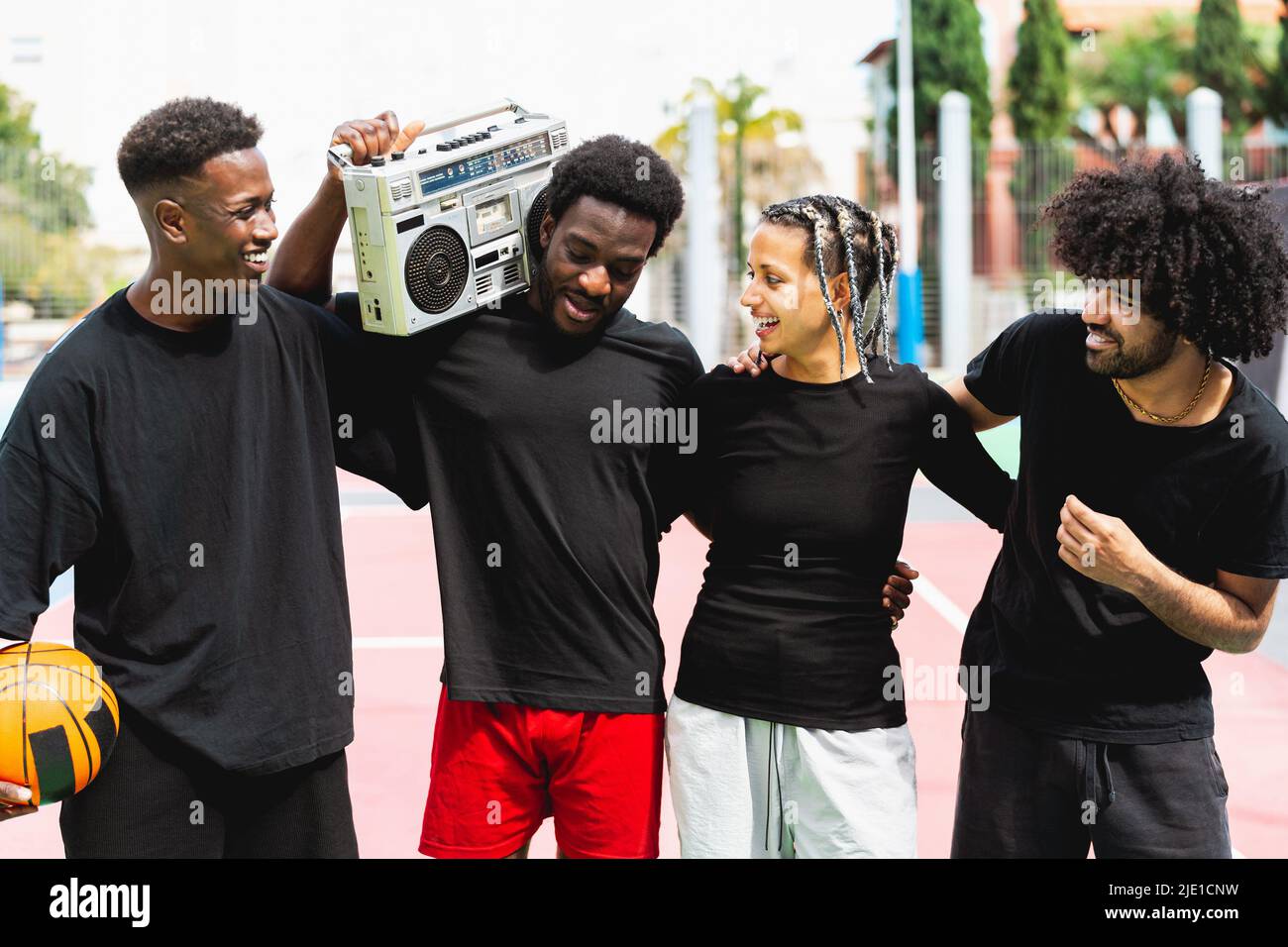 Young African American people having fun listening music with vintage boombox outdoor - Urban street people lifestyle Stock Photo