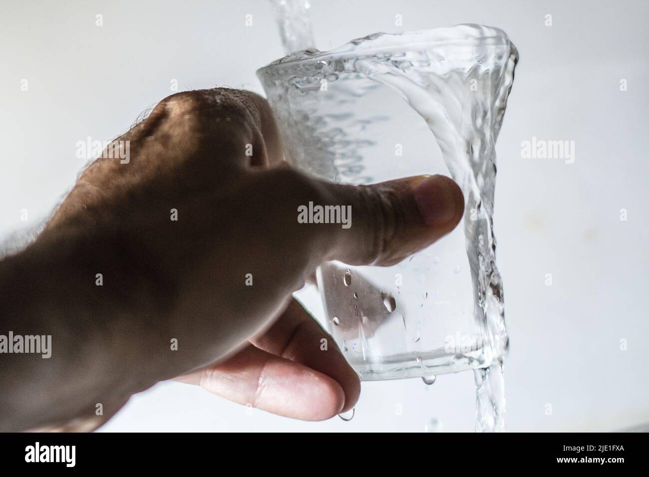 June 24, 2022, Rome, Italy: A man fills a glass with tap water. Lazio on 20 June declared a state of calamity for drought that has hit the central Italian region and many others, especially in the north. Lazio Governor Nicola Zingaretti said the move was aimed at taking measures such as saving water in all activities starting with household consumption. A drought alert has spread from the Po valley, where waters are three quarters down amid the worst drought in 70 years, to central rivers like the Arno, the Aniene and the Tiber, which have half the water they normally do at this time of the ye Stock Photo
