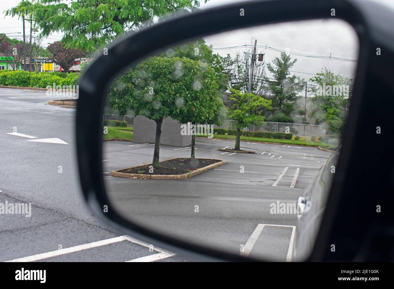 Empty parking spaces at a New Jersey strip mall after a brief downpour viewed through a car's side mirror -02 Stock Photo