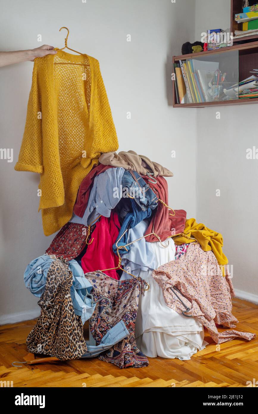 Hand throws clothes into a pile with used clothes. The concept of