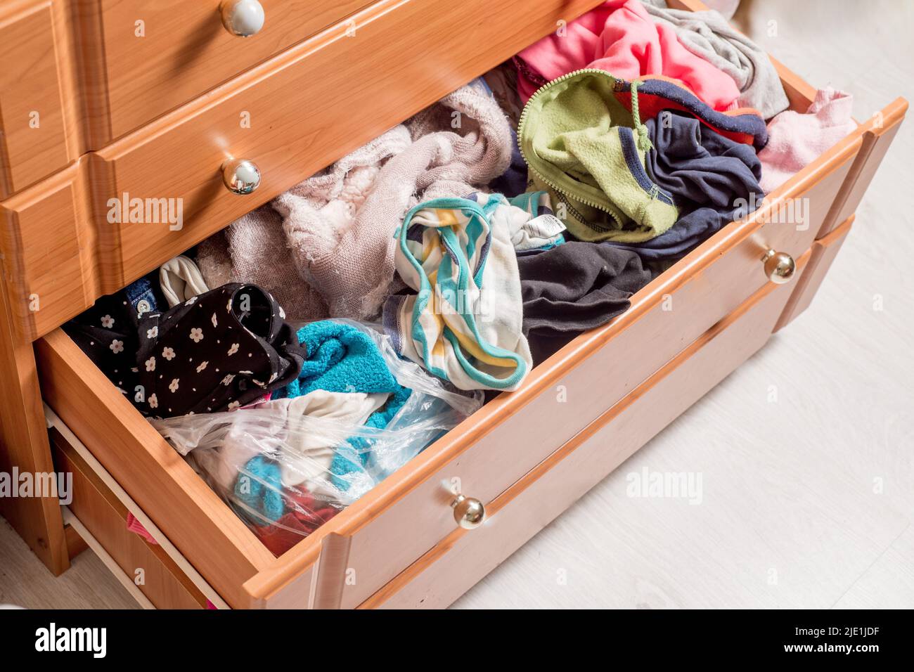 open chest drawers with sticking out randomly clothes.View from above