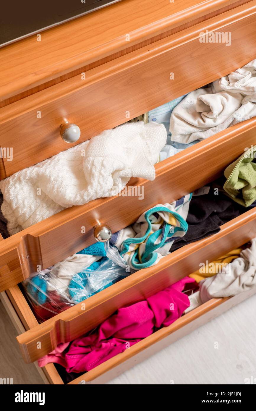 open chest drawers with sticking out randomly clothes.View from above