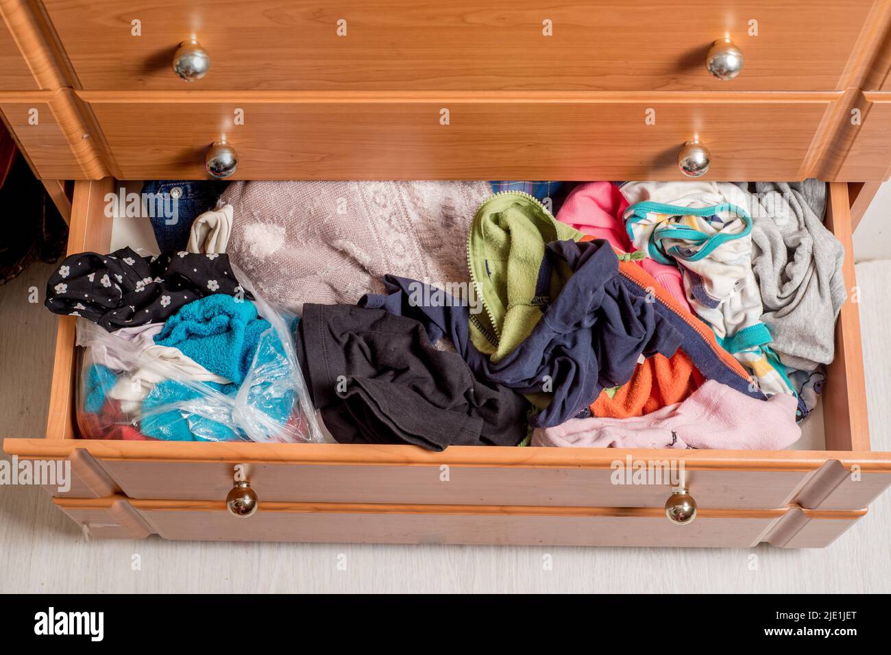 open chest drawers with sticking out randomly clothes.View from above