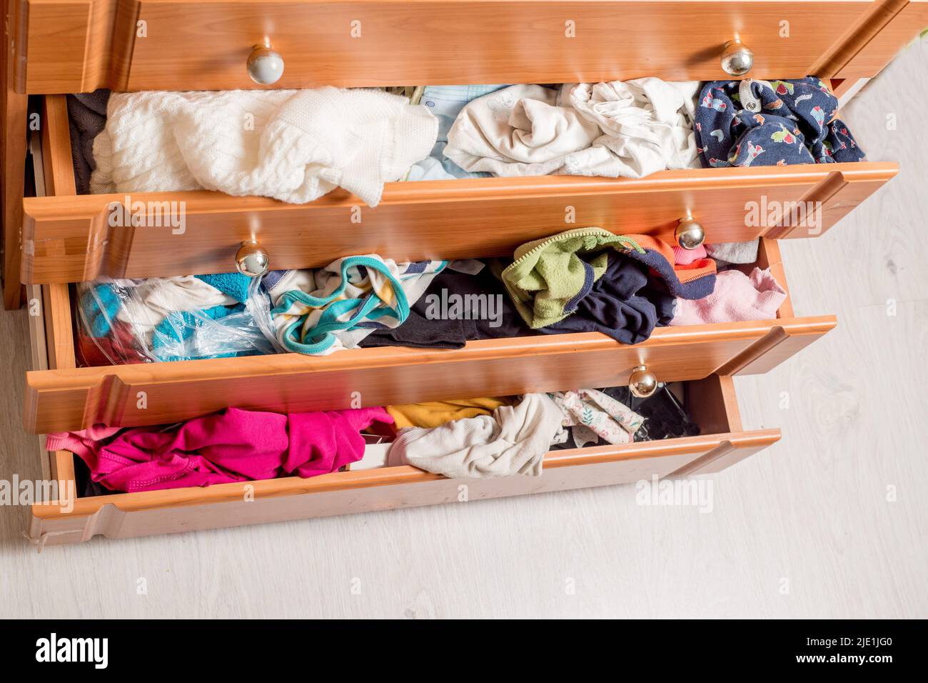 open chest drawers with sticking out randomly clothes.View from above