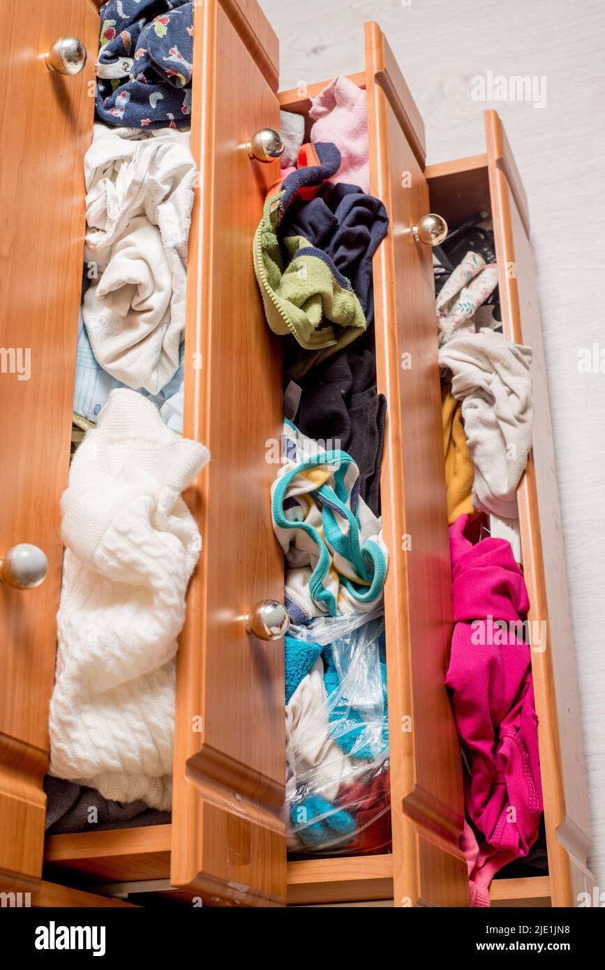 open chest drawers with sticking out randomly clothes.View from above
