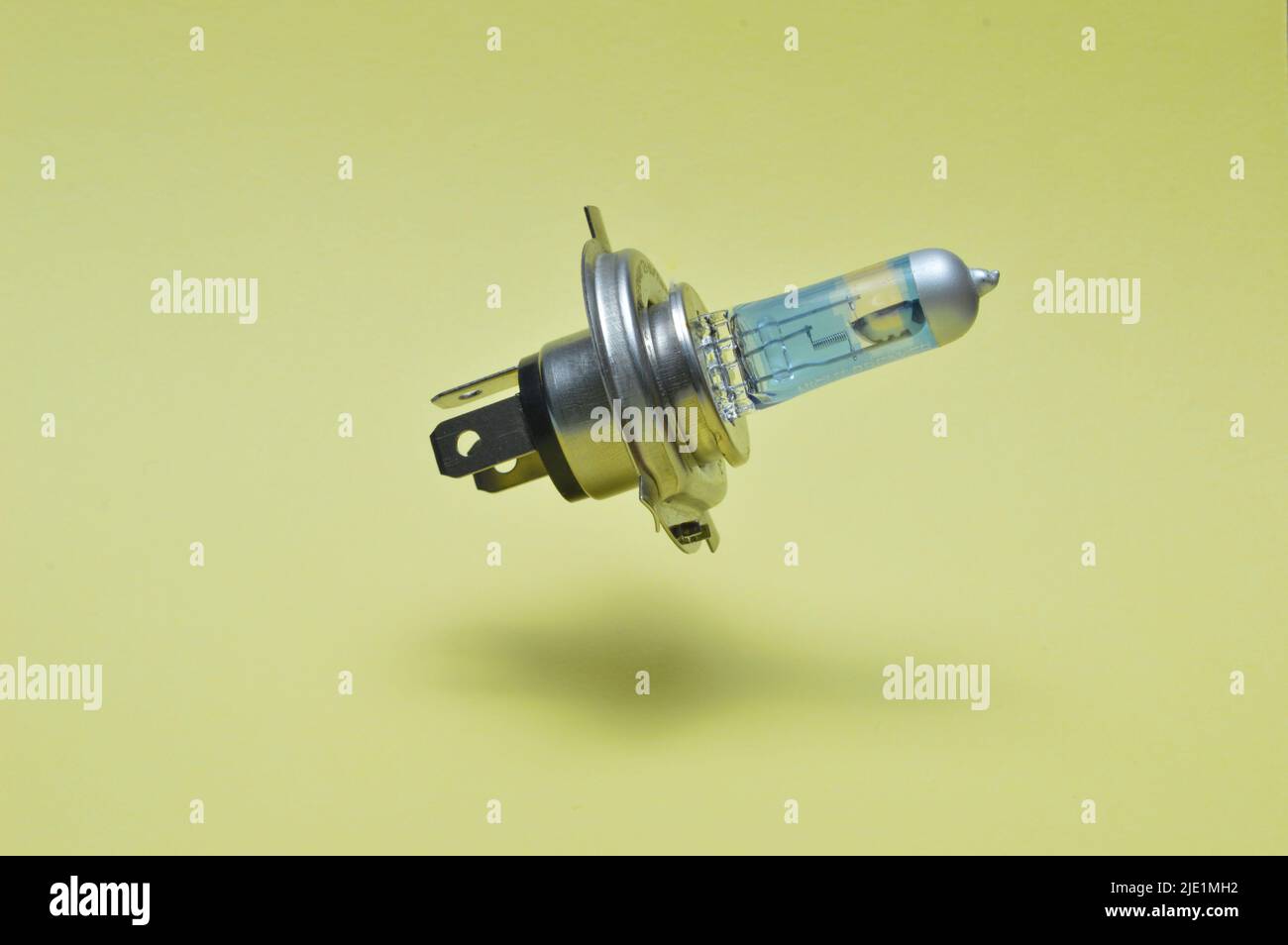 Halogen car headlight bulb isolated on yellow Stock Photo