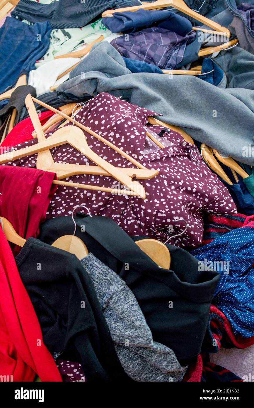 Lots of clothes on hangers piled in a pile. Cleaning the wardrobe