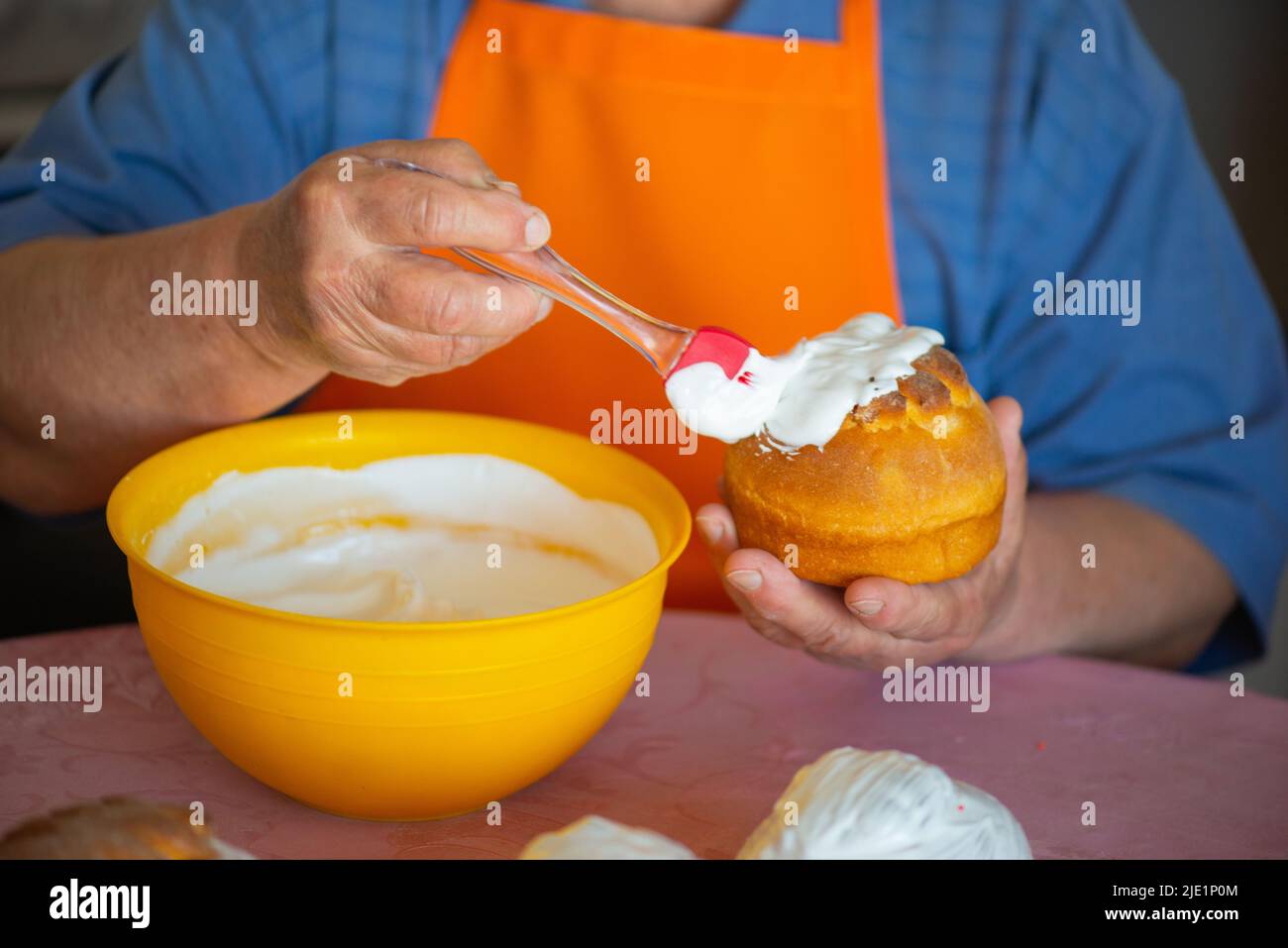 one grandmother smears Easter cake with protein cream Stock Photo