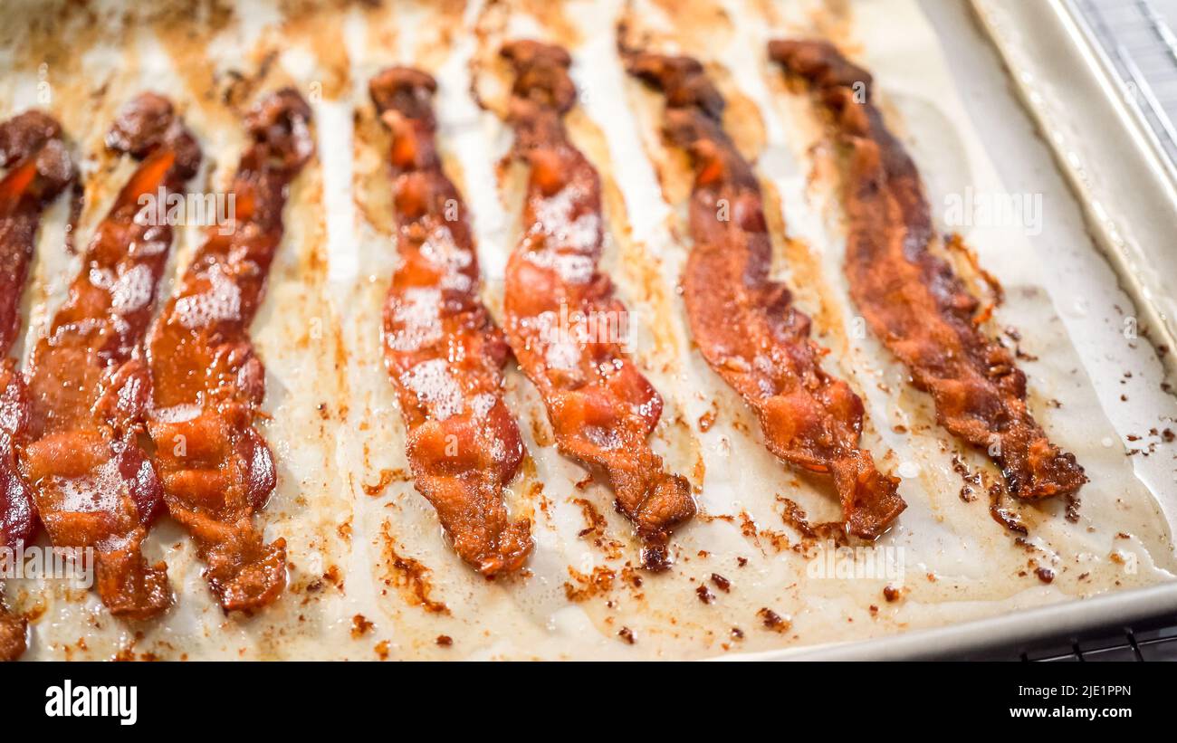 Step by step. Cooked bacon strips on a baking sheet with white