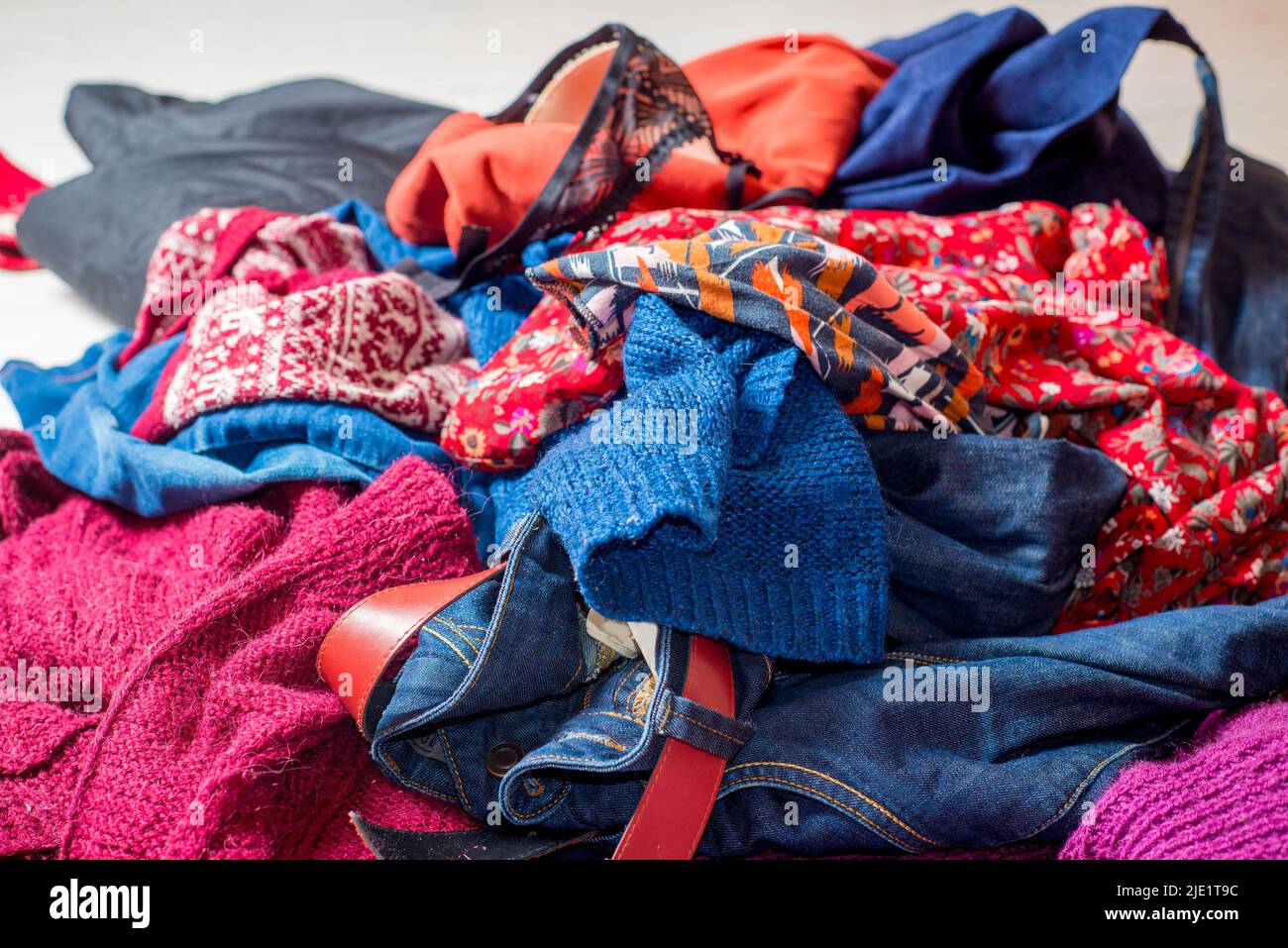 Dump of used clothes. Pile of scattered secondhand clothes on a white