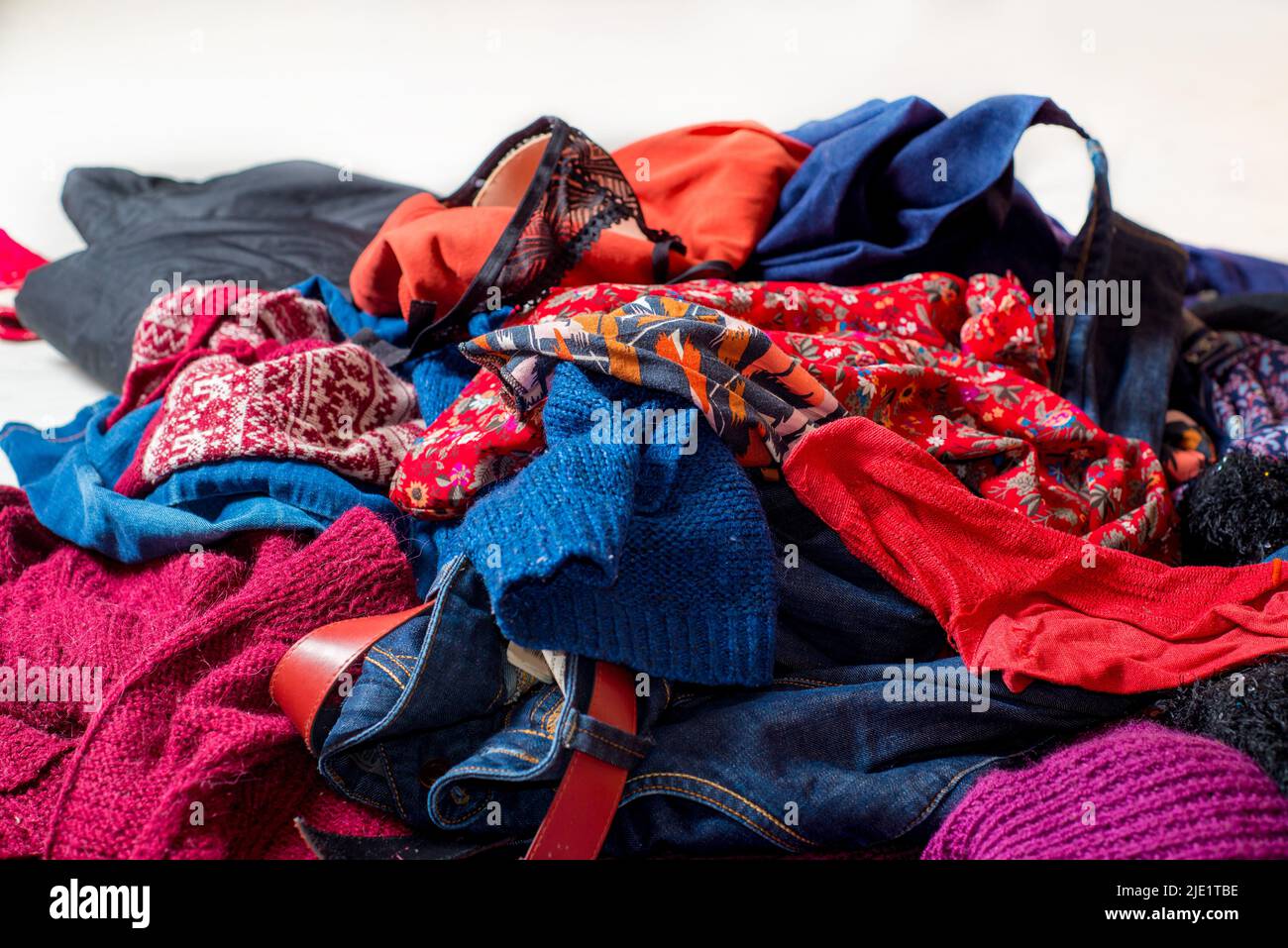 Landfil of used clothes. Pile of scattered secondhand clothes on a