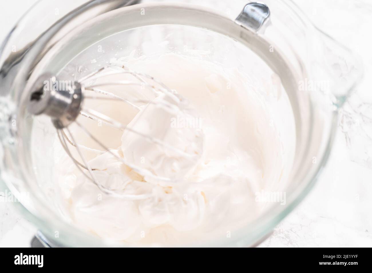 Making meringue in kitchen mixer to bake unicorn meringue cookies Stock