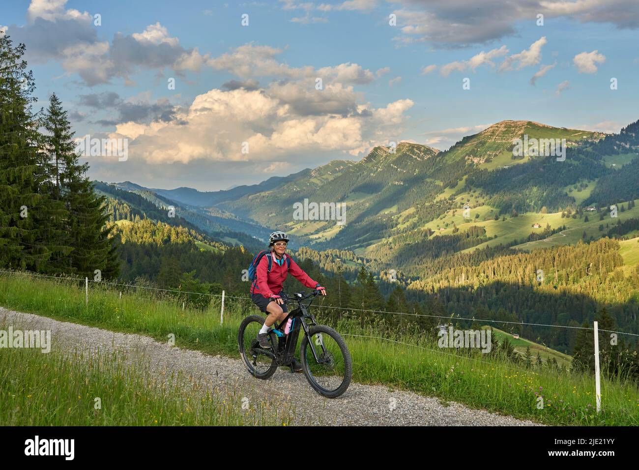 pretty senior woman riding her electric mountain bike on the mountains ...