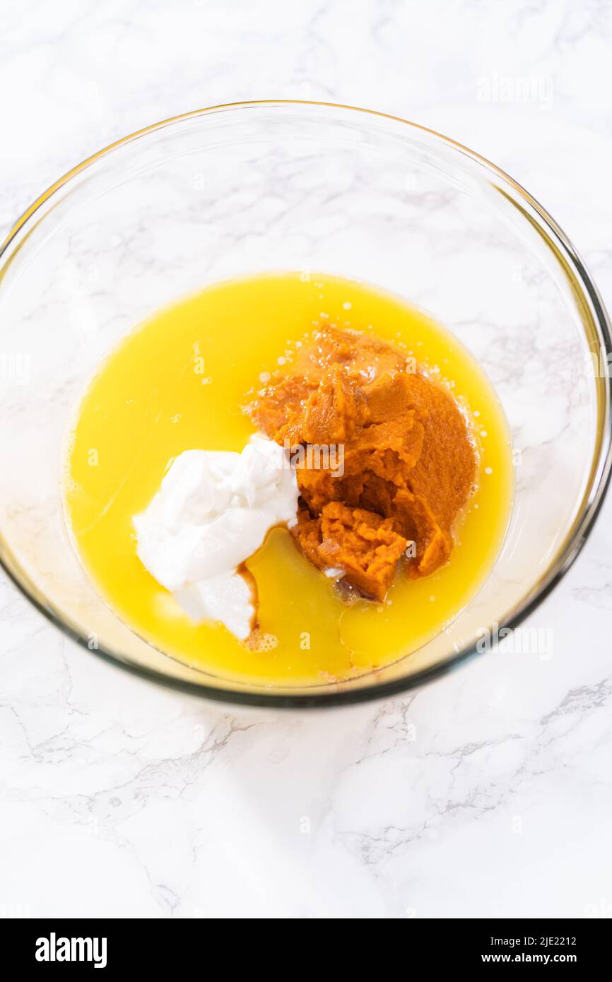 Mixing ingredients in a large glass mixing bowl to bake chocolate