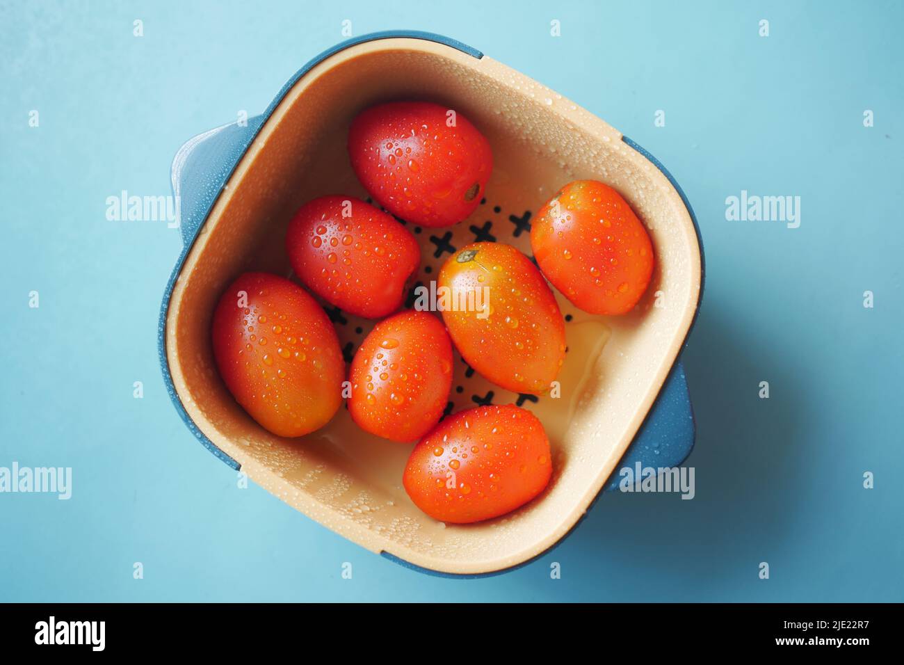 cleaning fresh tomato with a water in a plastic bowl Stock Photo - Alamy