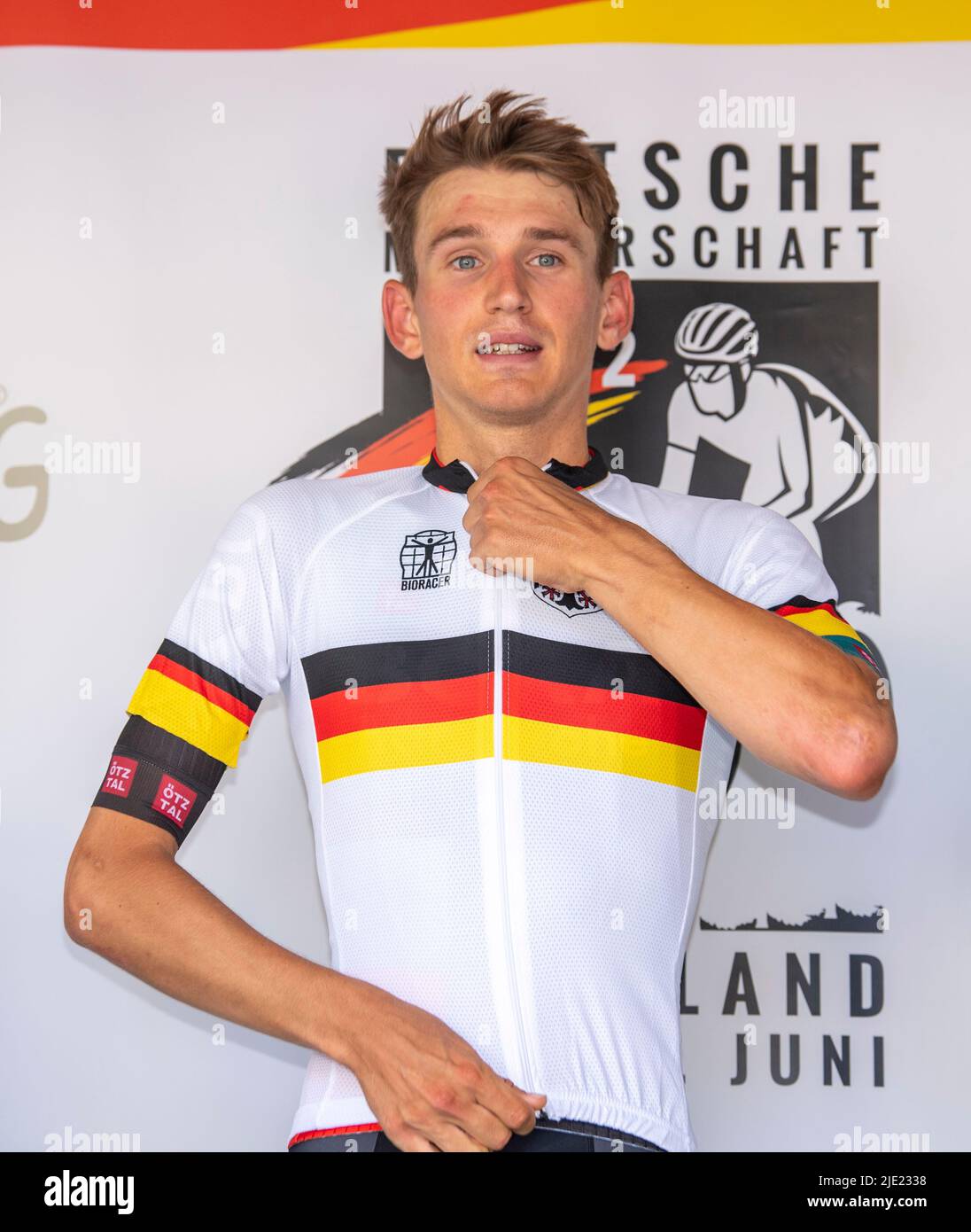 Marsberg, Germany. 24th June, 2022. Cycling: German Championship, men's individual time trial (27.48 km), winner Marco Brenner puts on the jersey of the German Champion. Credit: David Inderlied/dpa/Alamy Live News Stock Photo