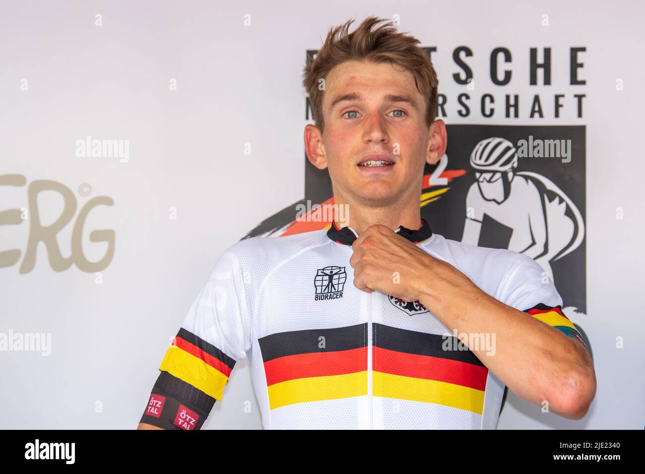 Marsberg, Germany. 24th June, 2022. Cycling: German Championship, men's individual time trial (27.48 km), winner Marco Brenner puts on the jersey of the German Champion. Credit: David Inderlied/dpa/Alamy Live News Stock Photo