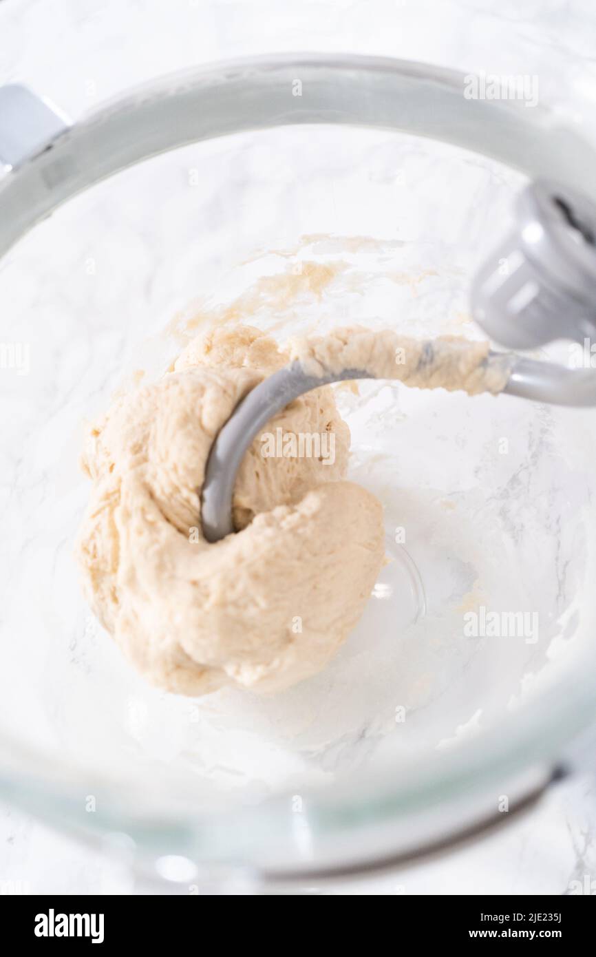 https://c8.alamy.com/comp/2JE235J/mixing-ingredients-in-a-large-glass-mixing-bowl-to-pizza-dough-2JE235J.jpg