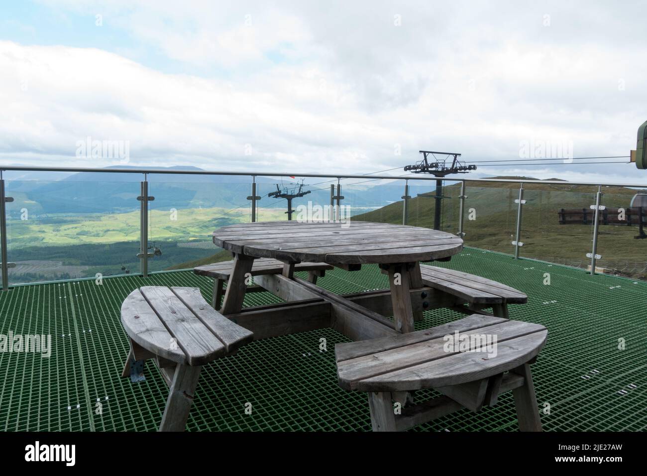 Picnic table at Nevis Range Restaurant with a view of Scottish highland mountain range Stock Photo