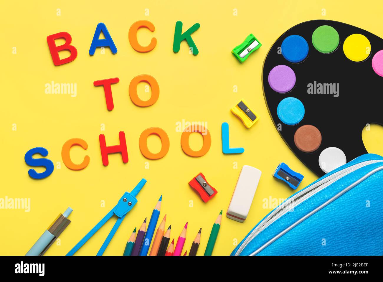 Top view of school supplies with the word Back to school on yellow background. Back to school concept Stock Photo