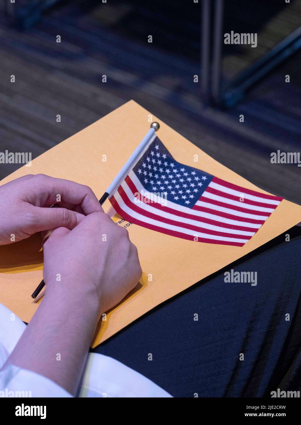 Austin, TX, USA. 24th June, 2022. A woman holds an American flag as 95 new  United States citizens from 40 foreign countries take the oath of  allegiance led be a federal judge