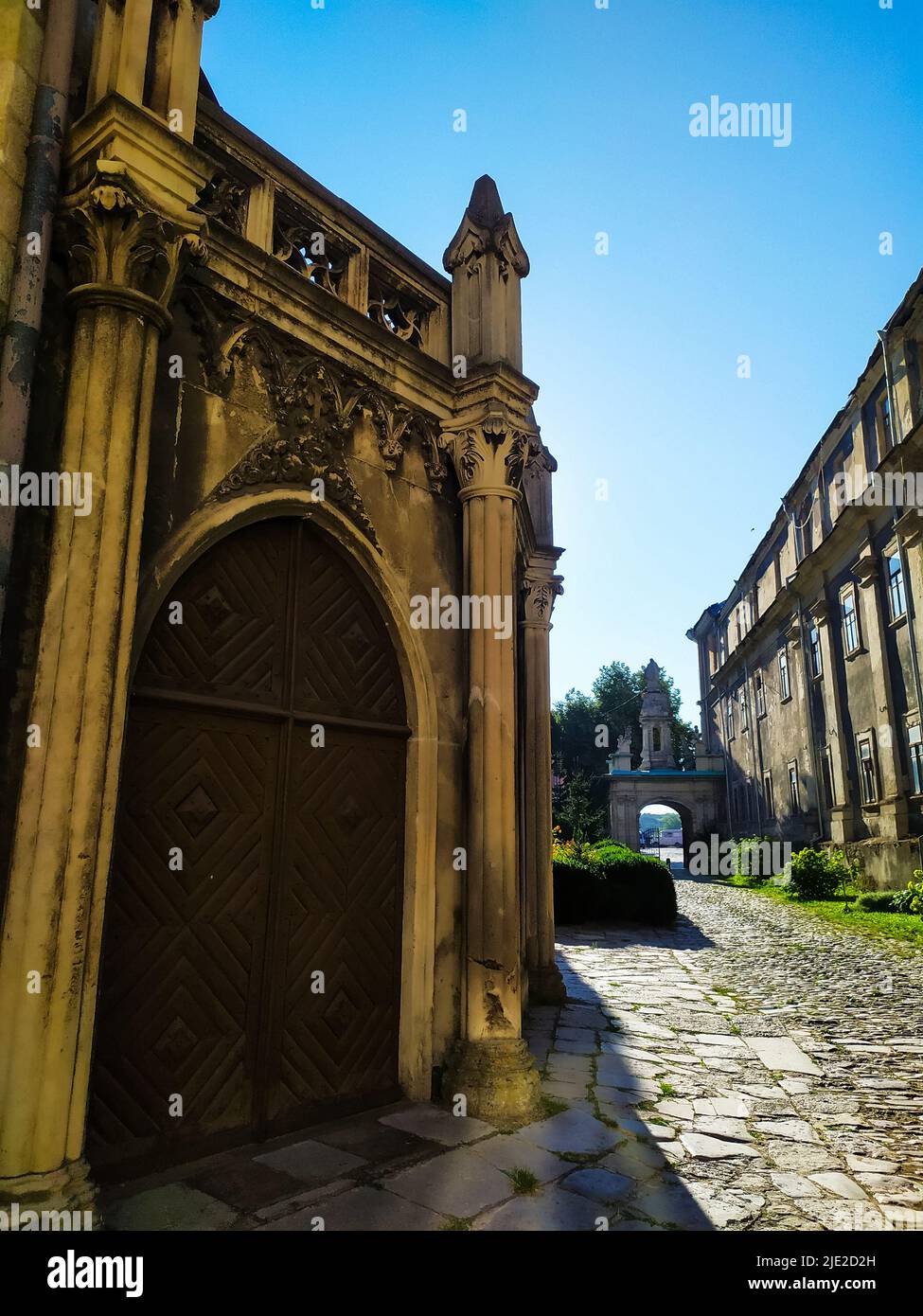 two-leaf wooden door under a semicircular arch of stone Stock Photo