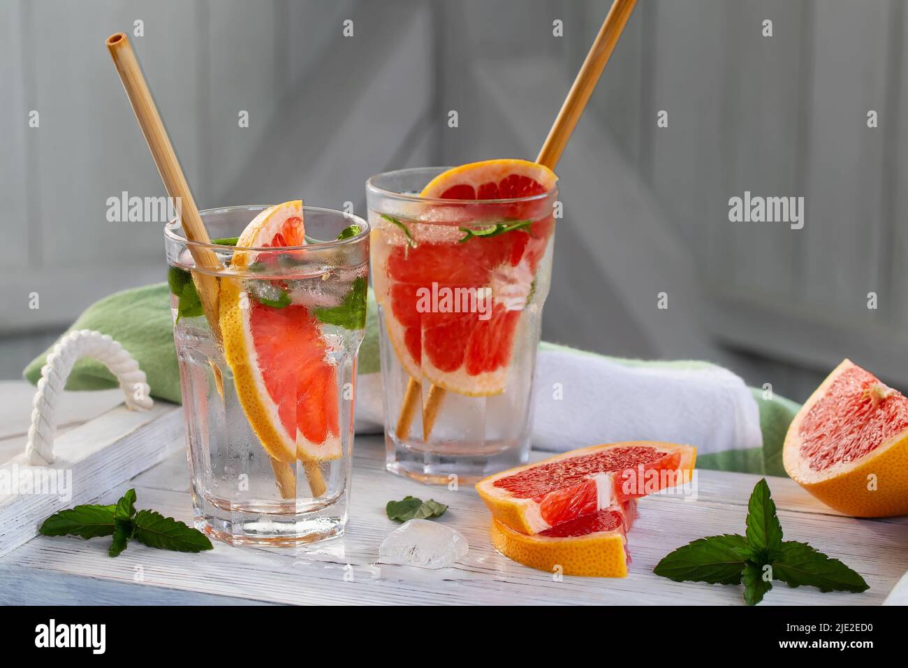 Summer refreshing cocktails with grapefruit slices and mint on a white