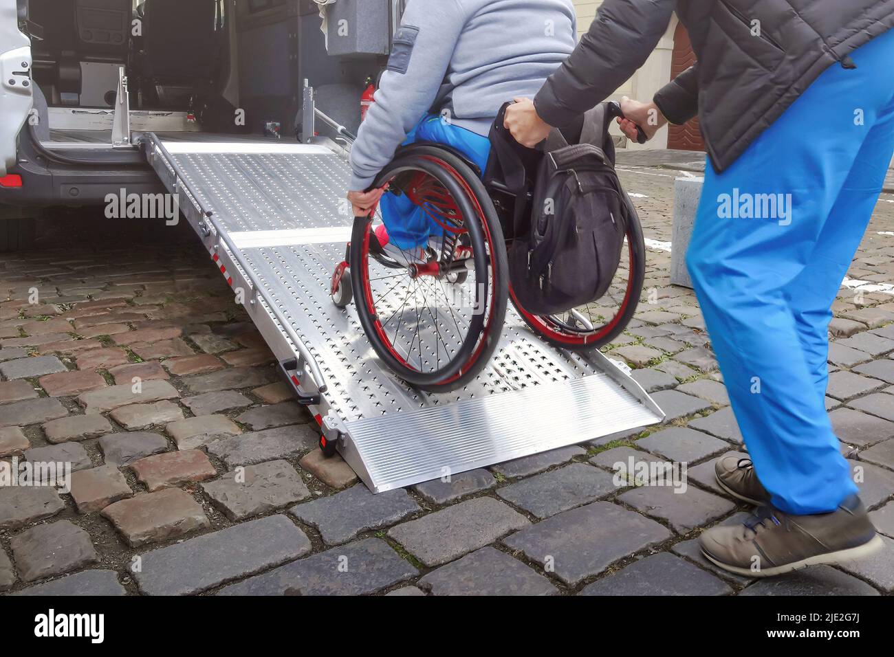 Person on wheelchair with disability using accessible car ramp for