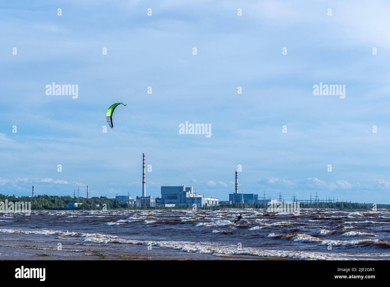 Kitesurfing at sea against the background of a nuclear power plant Stock Photo