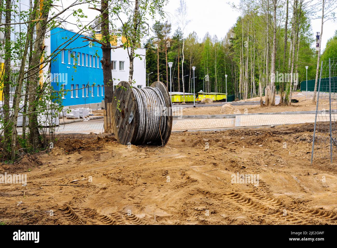 wooden coil with an electric cable is lying on a construction site Stock Photo