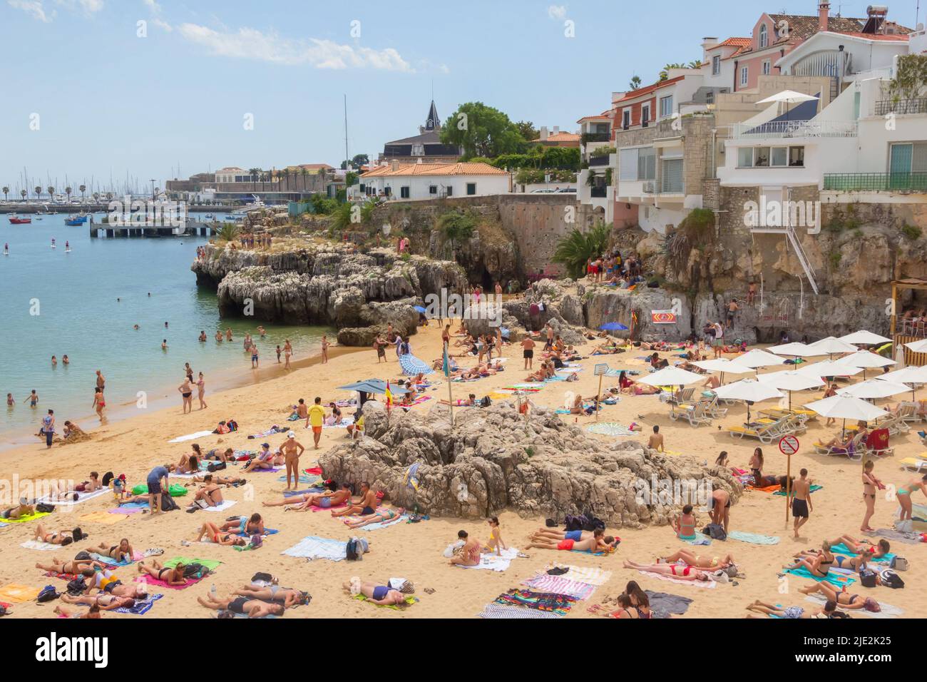 Cascais, Portugal - June 22, 2018: Cascais near Lisbon, seaside town. Panoramic view with port and beach, filled with resting people in a summer sunny Stock Photo