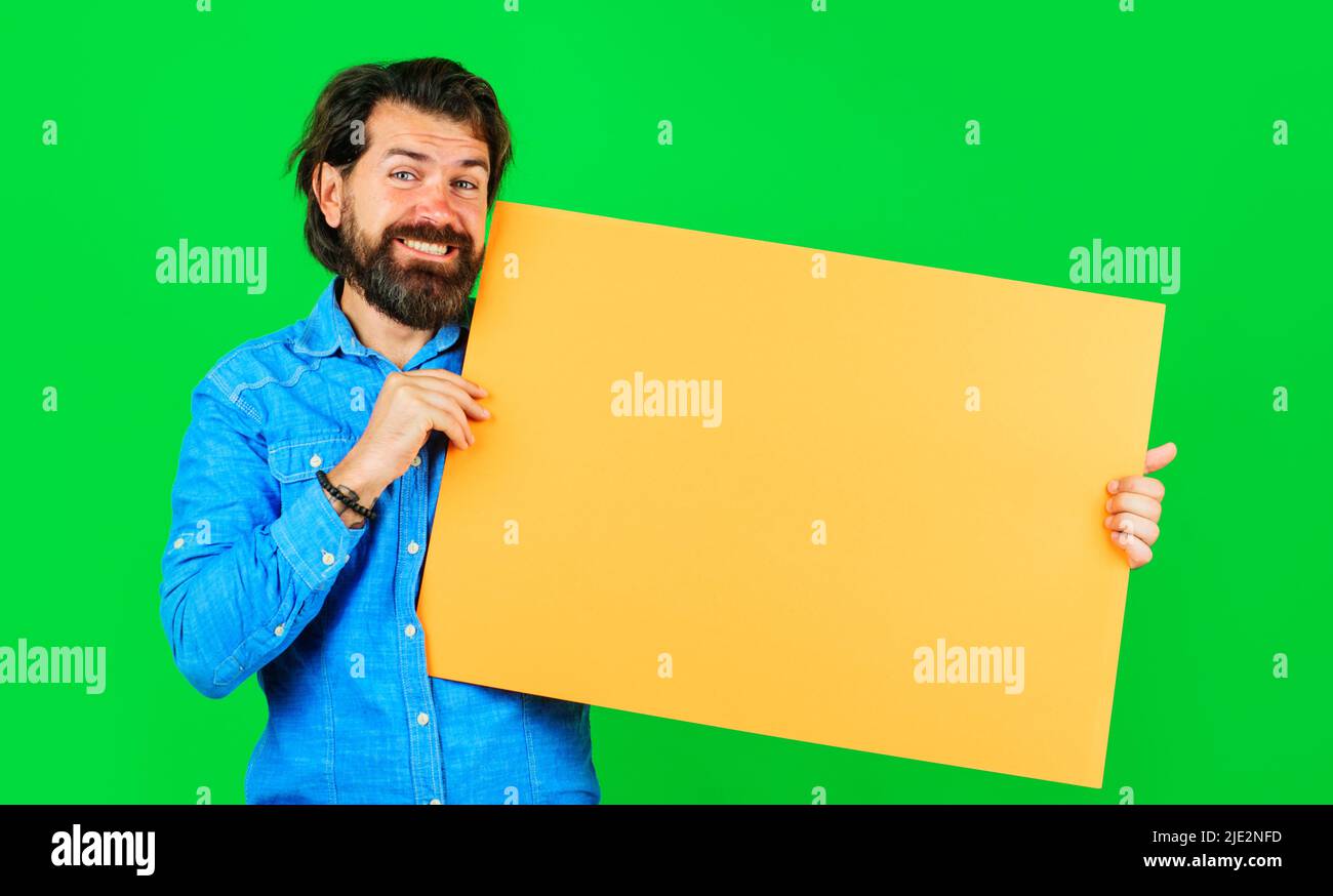 Smiling bearded man with empty board. Advertising banner. Season sales. Online shopping. Marketing. Stock Photo