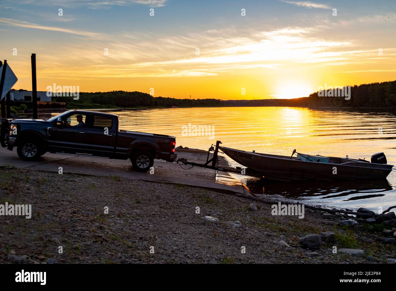 Peoria, Illinois - As the sun rises over the Illinois River, Dave Buchanan backs his fishing boat into the water to check his lines for catfish. He us Stock Photo