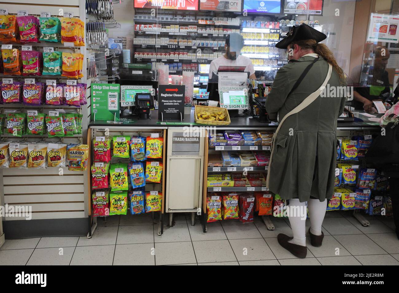 A tour guide dressed in a period costume makes a purchase at a convenience store in Boston, Massachusetts, U.S., June 24, 2022.   REUTERS/Brian Snyder Stock Photo