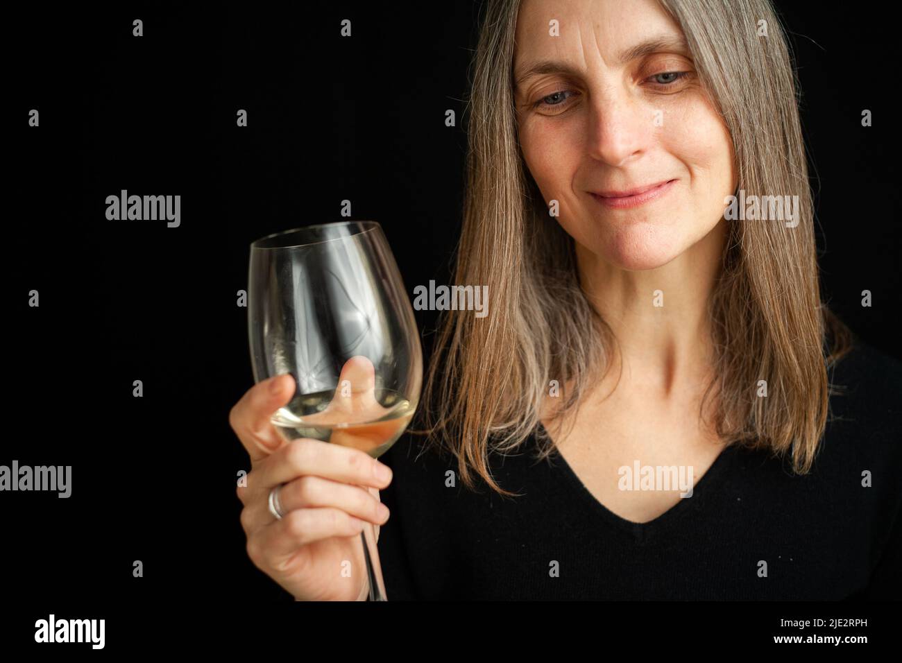 A fine wine. A portrait of a mature woman enjoying a glass of wine ...