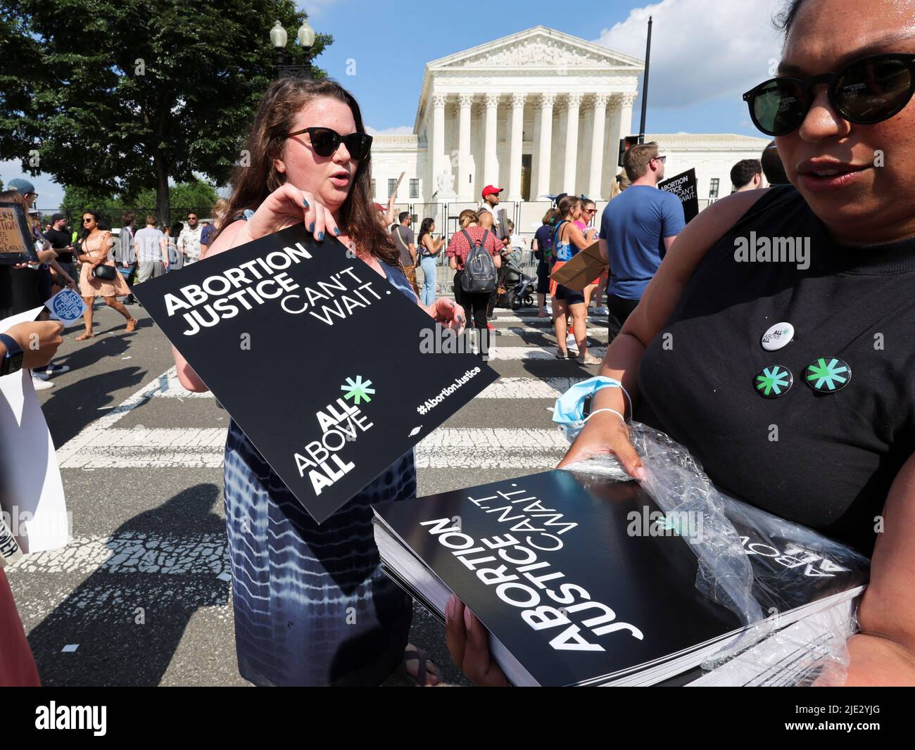 Daniela Diaz (R) from Venezuela who had an abortion in Washington, DC, hands out posters during a protest outside the United States Supreme Court as the court rules in the Dobbs v Women's Health Organization abortion case, overturning the landmark Roe v Wade abortion decision, in Washington, DC, U.S., June 24, 2022. REUTERS/Jim Bourg Stock Photo