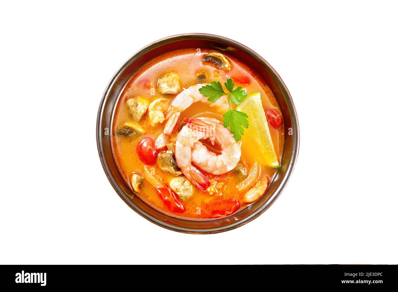 Thai soup Tom Yam from shrimps, chicken meat with mushrooms, tomatoes and lemon in a bowl isolated on a background from above Stock Photo
