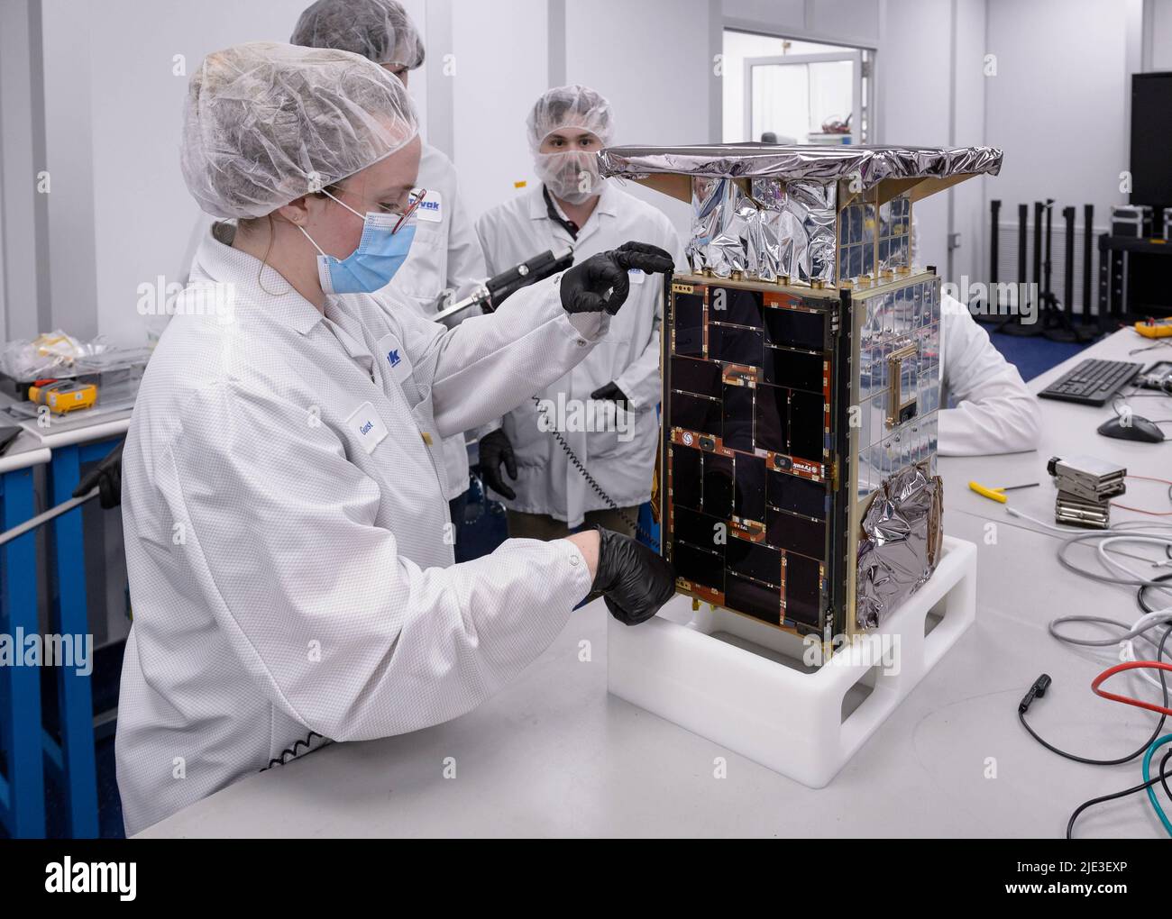 June 24, 2022: In this image from April 2022 Rebecca Rogers, systems engineer, left, takes dimension measurements of the CAPSTONE spacecraft at Tyvak Nano-Satellite Systems, Inc. in Irvine, California. Cislunar Autonomous Positioning System Technology Operations and Navigation Experiment, or CAPSTONE is slated to launch on Monday, June 27, aboard a Rocket Lab Electron rocket from the company's Launch Complex 1 in Mahia, New Zealand. The destination for this microwave oven-size CubeSat is a near rectilinear halo orbit (NRHO). CAPSTONE, the pathfinder for NASA's lunar outpost, will test an orbit Stock Photo
