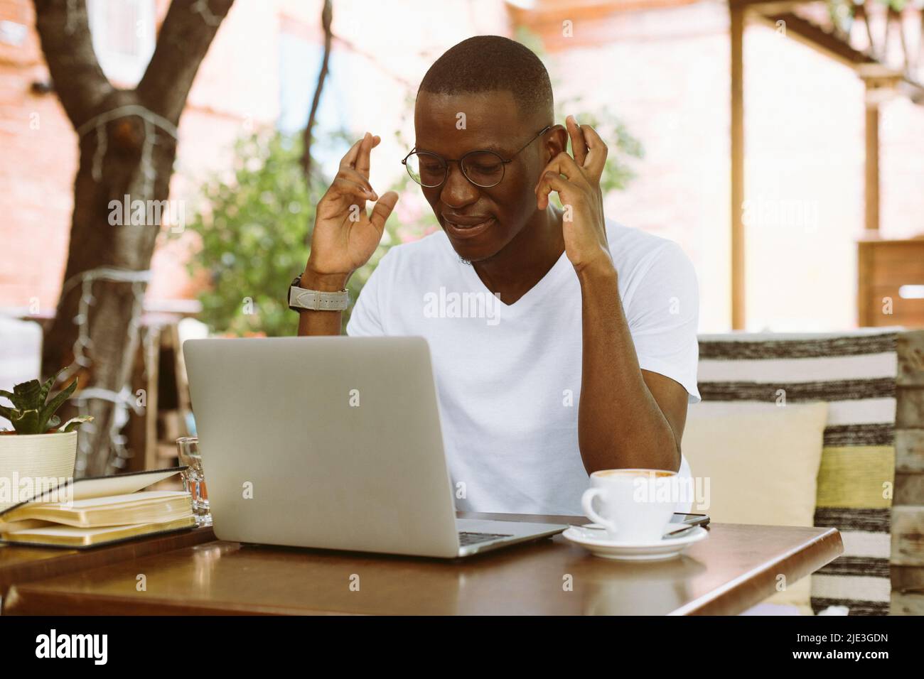 Smiling african american businessman work on laptop in the cafe ...