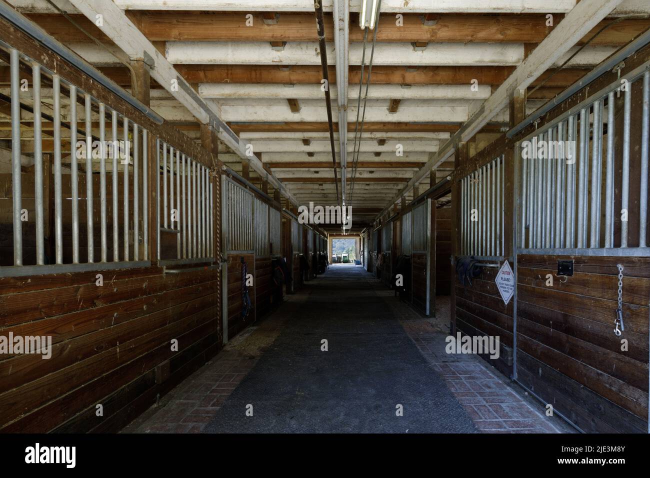 Empty Horse Stall Hallway in Stables in North America Stock Photo