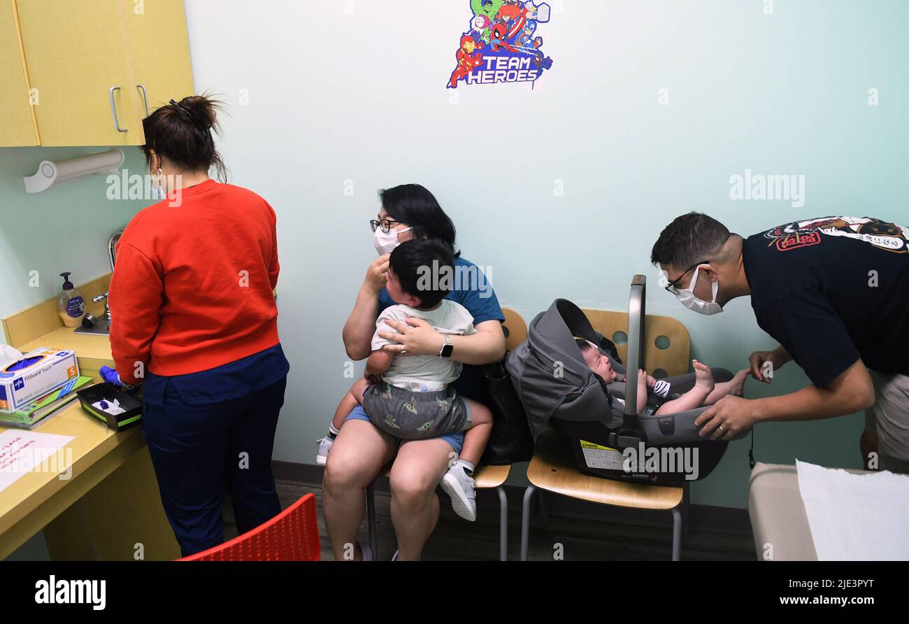 Yingxue Ren and Adrian Perez hold their 2-year-old and 6-month-old children while a nurse prepares to administer the Moderna Covid-19 vaccine at Nona Pediatric Center in Orlando. On June 18, 2022, the Centers for Disease Control and Prevention (CDC) recommended that all children 6 months through 5 years of age should receive a COVID-19 vaccine. Florida Governor Ron DeSantis has refused to order doses of the vaccine for state heath departments, making Florida the only state not providing the vaccine for young kids. Stock Photo