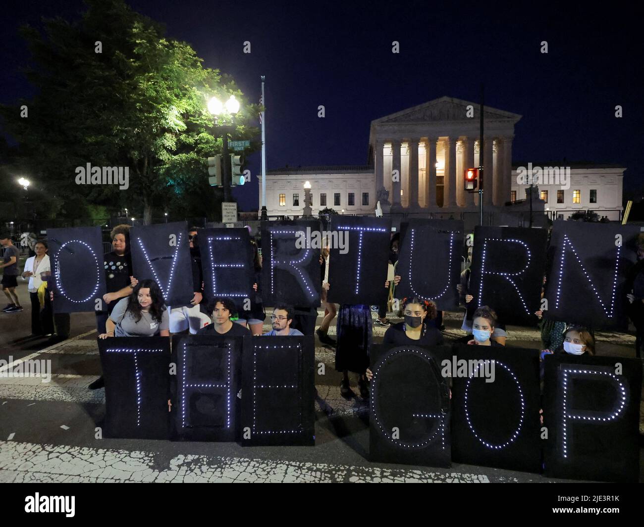 Protesters lit up a sign reading 'Overturn the GOP' which means the Republican Party which is know as the Grand Old Party (GOP), during a demonstration outside the United States Supreme Court as the court rules in the Dobbs v Women's Health Organization abortion case, overturning the landmark Roe v Wade abortion decision in Washington, U.S., June 24, 2022. REUTERS/Jim Bourg Stock Photo