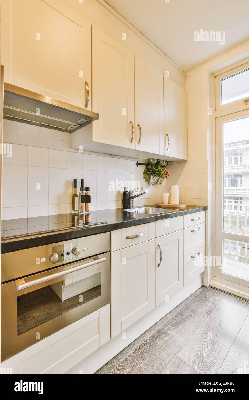 Interior of a bright kitchen with balcony doors in a modern apartment at daytime Stock Photo