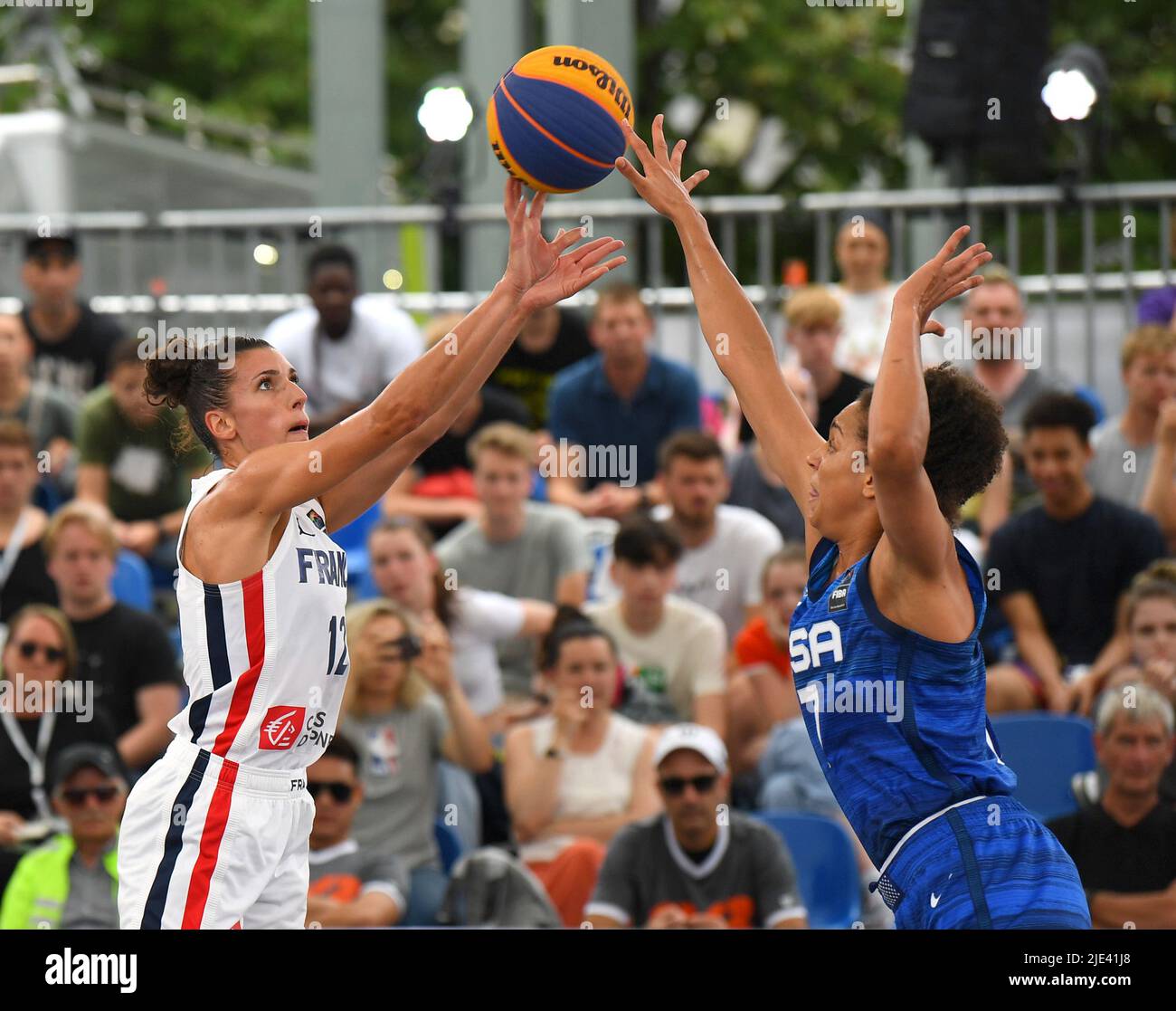 Antwerp, Belgium. 24th June, 2022. Laetitia Guapo (L) of France shoots under the defense of Cierra Burdick of the United States during the FIBA 3X3 World Cup women's pool round match between the United States and France in Antwerp, Belgium, June 24, 2022. Credit: Ren Pengfei/Xinhua/Alamy Live News Stock Photo