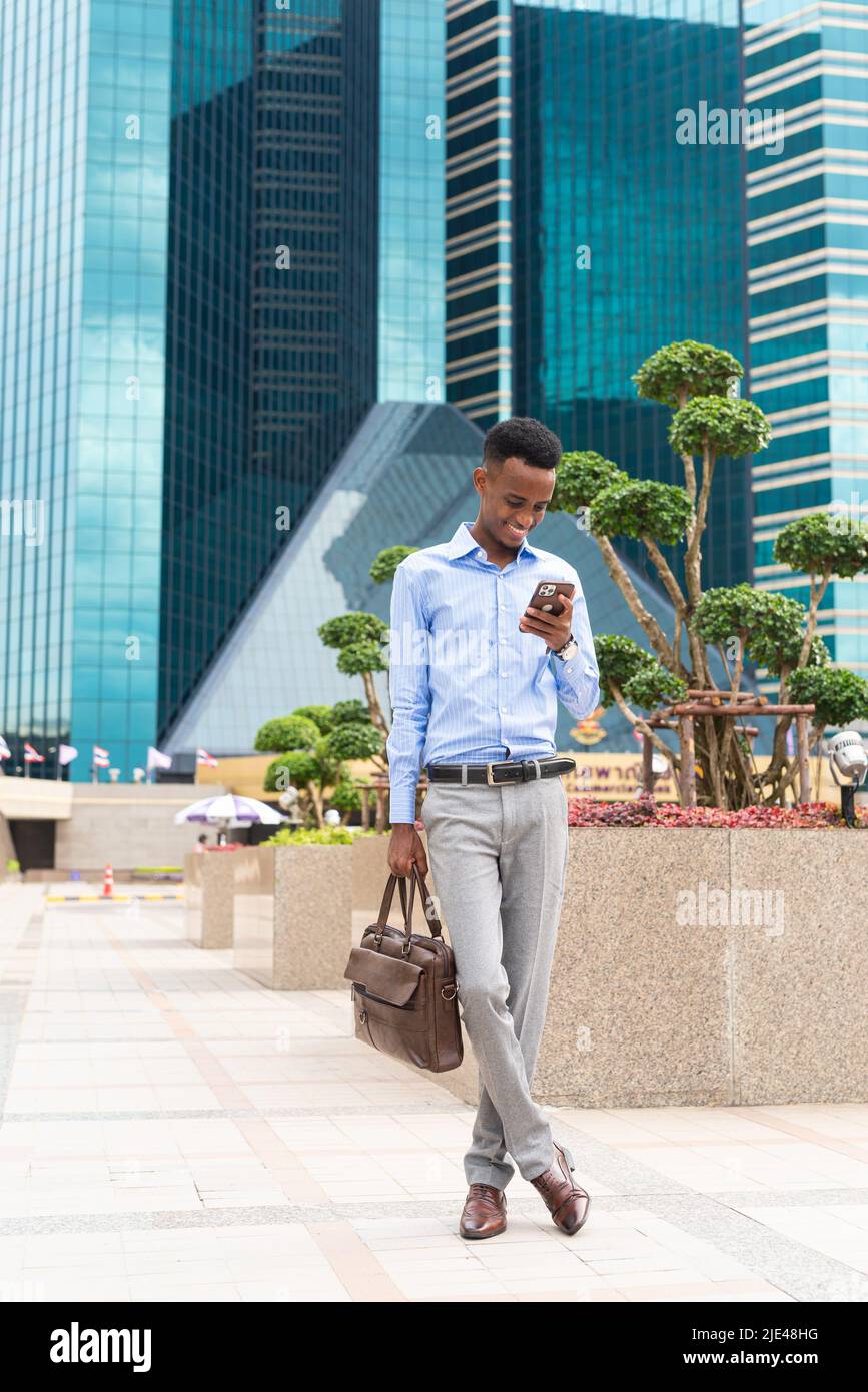 Handsome young black businessman outdoors in city Stock Photo