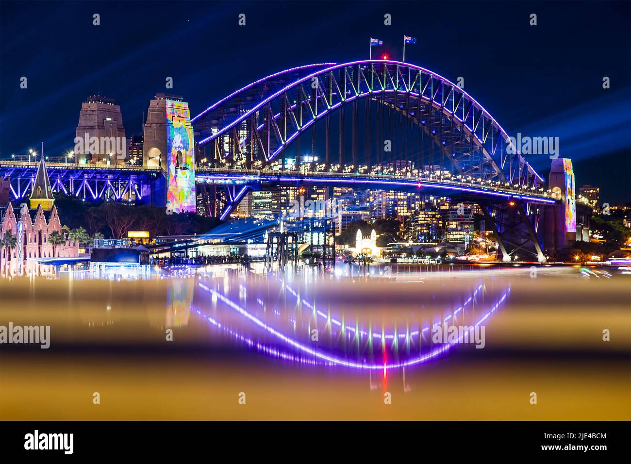 Bright glossy arch of the Sydney Harbour bridge reflecting at Vivid Sydney light show festival at night in Australia. Stock Photo